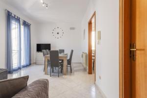 a living room with a table and chairs and a television at Contessa Vacanze Byron in Contessa Entellina