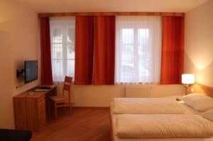 a bedroom with two beds and a desk with a television at Norling Guest House in Vienna