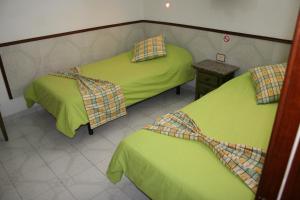 2 camas en una habitación con sábanas verdes en Apartamentos Maba Playa, en Playa del Inglés