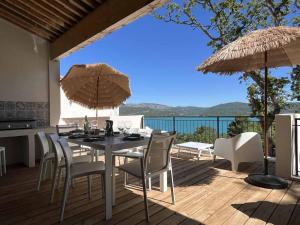een eettafel met stoelen en parasols op een terras bij Villa Fautea Verdon in Sainte-Croix-de-Verdon