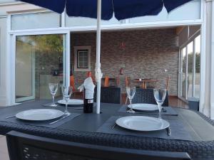 a black table with a bottle of wine and glasses at AL Recanto do Sol in Torres Novas