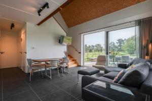 a living room with a couch and a table at Hello Zeeland - Vakantiewoning Kalfhoeksepad 8 in Aagtekerke