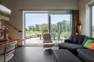 a living room with a couch and a table at Hello Zeeland - Vakantiewoning Kalfhoeksepad 8 in Aagtekerke