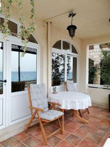 a porch with a table and two chairs and windows at Studio apartment Milna, Hvar Buratovic in Hvar