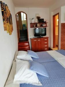 a bedroom with a bed with pillows and a mirror at Studio apartment Milna, Hvar Buratovic in Hvar