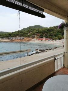 a balcony with a view of a beach and the water at Studio apartment Milna, Hvar Buratovic in Hvar +3 photos