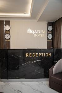 a hotel reception with clocks on a wall at Qadim Hotel in Samarkand