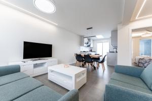 Una sala de estar con un sofá y un televisor. en 248 New Frontline Beach Mollina, en La Cala de Mijas