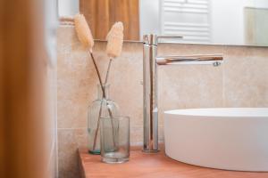 a bathroom with a glass vase with two brushes in it at Casa Rural Catalina in Camañas +7 photos