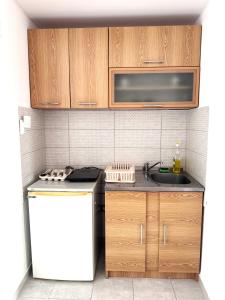 a kitchen with wooden cabinets and a sink at Villa Happy Family!!! in Prijevor +94 photos