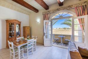 a living room with a table and chairs and a window at Villagg tal-Fanal in Għasri