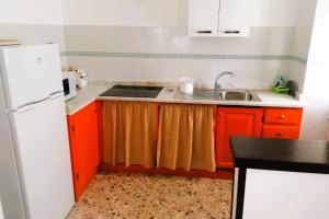 a kitchen with red cabinets and a white refrigerator at Domo Nina in La Spezia +3 photos