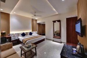 a hotel room with a bed and a tv at Sparsh Hotel & Resort in Bareilly