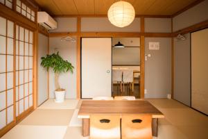 船橋市にあるBlessing Guest Houseの食卓と鉢植えの植物があるダイニングルーム