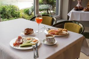 a table with plates of food and a glass of orange juice at Best Palanga Hotel in Palanga