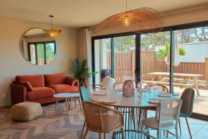 ラカノーにあるVilla Camélia Rose Vue mer et jacuzziのテーブルと椅子とソファのあるリビングルーム
