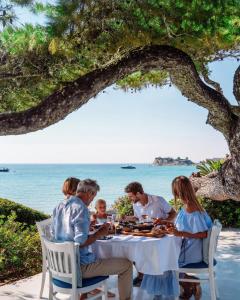 a family eating dinner at a table on the beach at Sani Club in Sani Beach