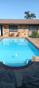 een groot blauw zwembad voor een gebouw bij Rose-Lee Cottage in Durban