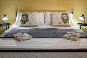 a bed with two towels on it with two lamps at Carmine House in Monreale