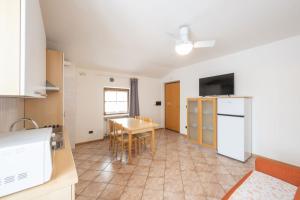 a kitchen and dining room with a table and a refrigerator at Residence Desiree in Riva del Garda