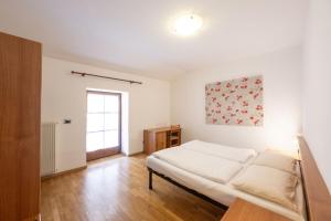 a white bedroom with a bed and a window at Residence Desiree in Riva del Garda