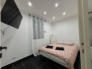 a bedroom with a bed with two black pillows on it at Chaleureux t1 Aiguebelle in Randens