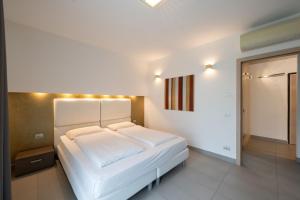 a bedroom with a white bed with lights on it at Residence Desiree in Riva del Garda