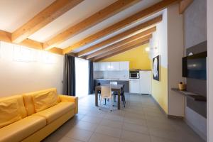 a living room with a yellow couch and a kitchen at Residence Desiree in Riva del Garda