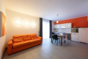 a living room with an orange couch and a table at Residence Desiree in Riva del Garda