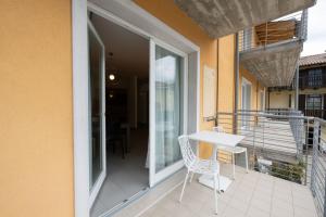 a balcony with a white table and chairs on it at Residence Desiree in Riva del Garda