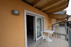 a balcony with a table and a chair on a building at Residence Desiree in Riva del Garda