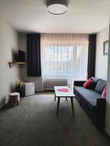 a living room with a couch and a coffee table at Hotel Salaš in Šenov u Nového Jičína