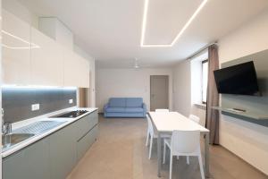 a kitchen with a table and a blue couch at Residence Desiree in Riva del Garda