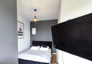 ein Schlafzimmer mit einem Bett und einem Flachbildfernseher in der Unterkunft Panorama Capital Tito - 16 piętro in Rzeszów
