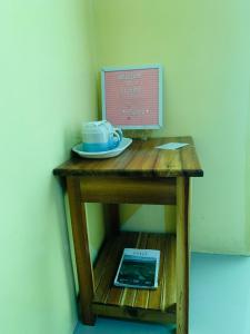 a small wooden table with a cup and a tablet on it at Francis Dale Lodge L7 in El Nido