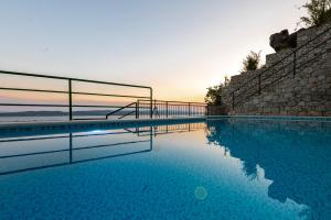 a swimming pool with the sunset in the background at Apartments with pool Maraska in Brela