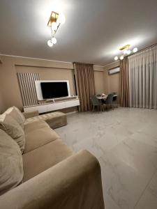 a living room with a couch and a flat screen tv at Luxury apartament in Mamaia Nord