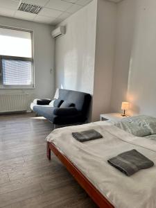 una camera da letto con un letto, una sedia e un divano di Spacious bungalow with parking a Bratislava