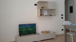 a living room with a flat screen tv on a white wall at Grazioso appartamento azzurro in Leuca