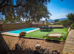 a backyard with a pool with a table and a bench at Casa Martí in El Vendrell