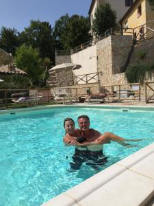 Un hombre y un niño en una piscina en vicino a San Gimignano, relax tra piscina e natura, fast internet STARLINK, en Gambassi Terme