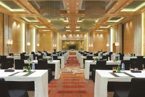 a restaurant with white tables and black chairs at Hyatt Regency Chennai in Chennai