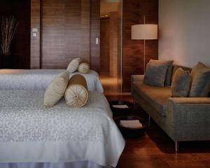 a hotel room with two beds and a couch at Hyatt Regency Chennai in Chennai