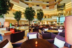 a restaurant with tables and chairs in a building at Hyatt Regency Chennai in Chennai
