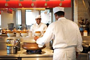 two chefs standing in a kitchen preparing food at Hyatt Regency Chennai in Chennai