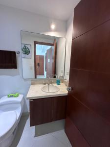 a bathroom with a sink and a toilet and a mirror at Cartagena De Indias in Cartagena de Indias