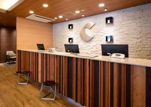 a lobby with a large counter with computers on it at Comfort Hotel Nara in Nara