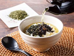a person is pouring tea into a bowl of food at Comfort Hotel Nara in Nara