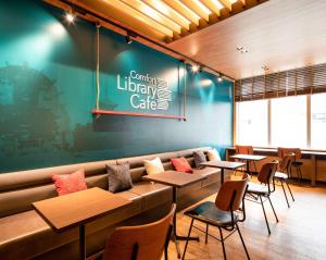 a restaurant with tables and chairs and a couch at Comfort Hotel Nara in Nara