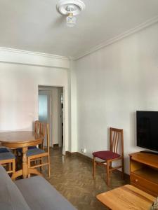 a living room with a table and chairs and a television at Virgen del Rio in Pamplona